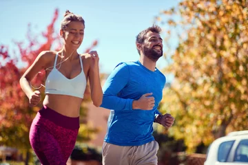  Jonge man en vrouw joggen in het park. gezonde levensstijl. © luckybusiness