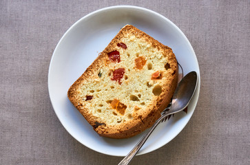 Slice of cake with candied fruit on a white plate 