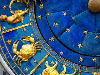 Cancer astrological sign on ancient clock. Detail of Zodiac wheel with crab. Golden symbol of Cancer on star circle closeup. Concept of astrology and horoscope.
