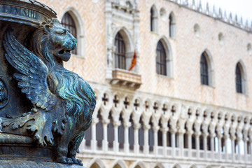 St Mark`s Square or Piazza San Marco, Venice, Italy. Detail with bronze sculpture of winged lion, symbol of Venice. Doge`s Palace in the background. Beautiful Renaissance architecture of Venice.