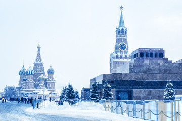 Moscow Red Square in winter, Russia. This place is a famous tourist attraction of Moscow. Cold winter view of St Basil Cathedral and Moscow Kremlin. Panorama of Moscow city center during snowfall.