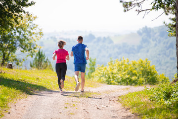 Obraz premium young couple jogging on sunny day at nature