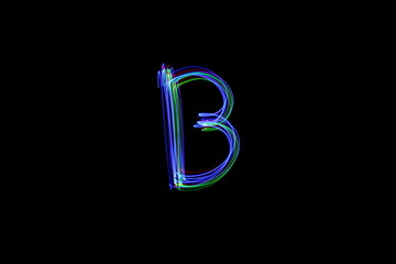 Long exposure photograph of  the letter b in upper case, neon multi colour in an abstract swirl, parallel lines pattern against a black background. Light painting photography.