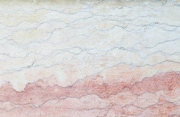 Close-up of an old, weathered, cracked and colorful stone wall. High resolution full frame textured background.