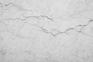 Close-up of an old, weathered and cracked stone wall with veins. High resolution full frame textured background in black and white.