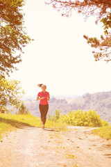 young woman jogging on sunny day at nature