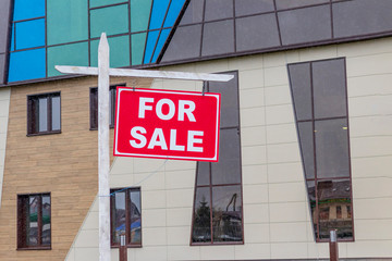 Naklejka premium daylight. hanging sign on it the inscription is on sale. in the background real estate.
