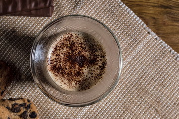 glass of cappuccino, chocolate and homemade cookies on burlap. Top view