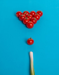 Cherry tomatoes on the pool table in the form of a pyramid and onions as a cue.