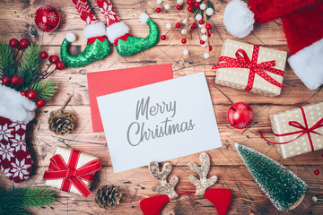 Christmas greeting card with gift boxes, santa hat and  decorations on wooden background. Top view from above