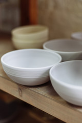 Fototapeta na wymiar Gray handmade ceramic plates. Glazed clay plates in a pottery workshop.