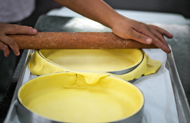 Closeup of hands preparing form to make pie