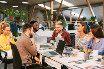 Creative start-up team discussing ideas in modern office