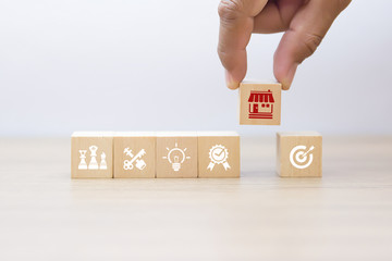 Businessman hand choose wooden blog with franchise marketing icons Store.