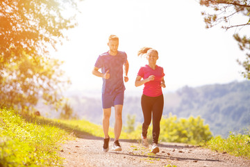 Fototapeta premium young couple jogging on sunny day at nature