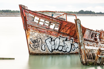 The Noirmoutier boats cemetery. The bow of the wreck of an old wooden fishing boat stranded and do...