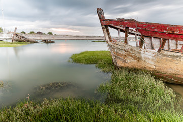 The Noirmoutier boats cemetery. The wreck of an old fishing boat is stranded on the vegetation that grows on the edge of the mudflat