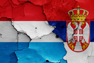 flags of Luxembourg and Serbia painted on cracked wall