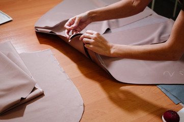 dressmaker sewing dress fabric with hand. Fashion designer tailor or sewer in workshop studio designing new clothes