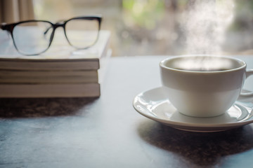 cup of coffee and book on wooden table