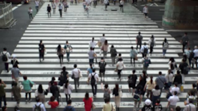 UMEDA, OSAKA, JAPAN - CIRCA SEPTEMBER 2019 : Aerial blurred high angle view of zebra crossing near Osaka train station. Crowd of people at the street. Shot in busy rush hour.