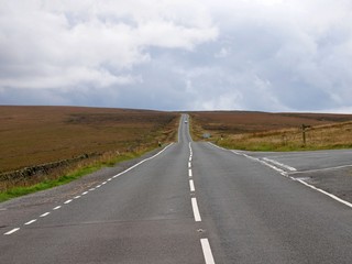 Fototapeta na wymiar Road leeding across the bleak moors from Holmfirth in Yorkshire England to Greenfield in Lancashire England