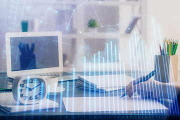 Financial graph displayed on woman's hand taking notes background. Concept of research. Multi exposure