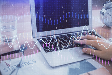 Multi exposure of market chart with man working on computer on background. Concept of financial...