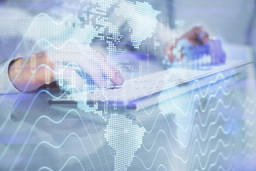 Double exposure of graph with man typing on computer in office on background. Concept of hard work. Closeup.