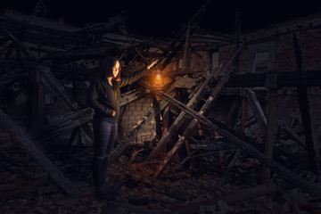 Girl lights a ruin with a lantern