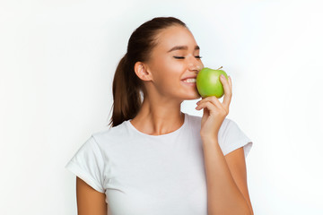 Cheerful Girl Eating Apple Standing Over White Background