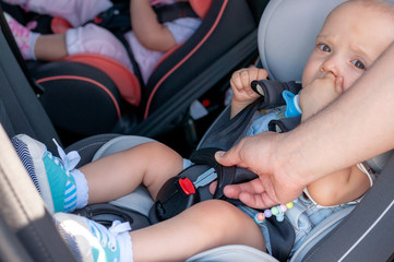 The process of fastening seat belts on a child restraint seat in the car. Safety for children, transport safety.