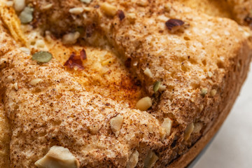 Sponge cake with apples, crushed walnuts and cinnamon, close-up