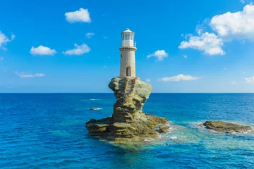 Gordijnen The beautiful Lighthouse Tourlitis of Chora in Andros island and a seagull, Cyclades, Greece © Aleh Varanishcha