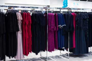 lot of women evening dresses on a hanger in the store