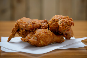 Three cooked, battered chicken drumsticks with copy space