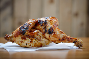 Half a cooked piri-piri chicken on table with copy space