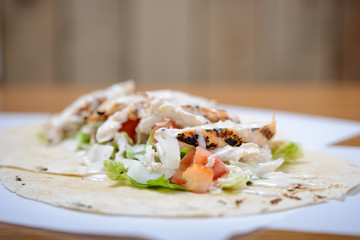 Close up of un-wrapped chicken and salad tortilla wrap 