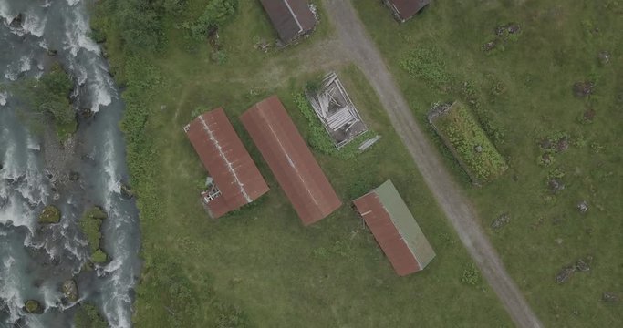 Red small house in the mountains 4k drone view of Norwegian houses and Briksdal, Briksdalsbreen glacier aerial shot colorful, river