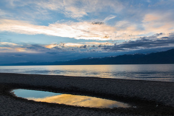 Issyk kul lake with mountains on background in Kyrgyzstan, near Karakol village