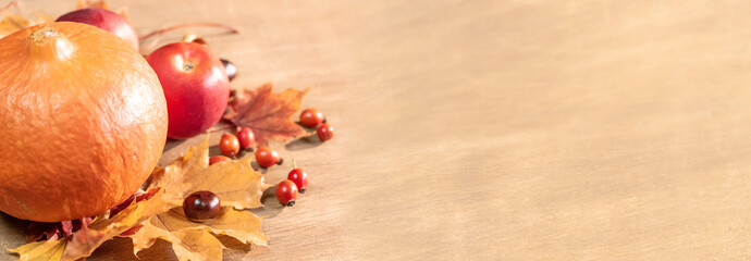 Autumn, autumn leaves, pumpkin and apples on a wooden table background. Panoramic image
