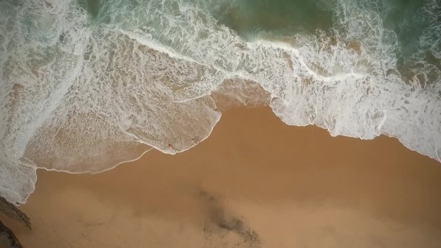 Aerial view waves break on white sand beach. Sea waves on the beautiful beach aerial view drone