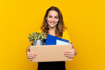 Young blonde girl making a move while picking up a box full of things