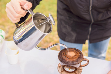 Pouring hot water on ground coffee, hand drip coffee
