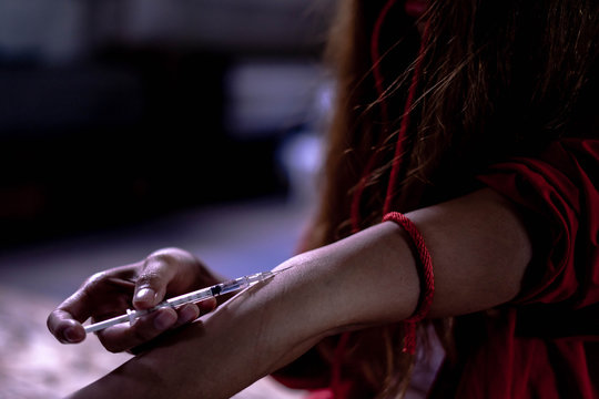 Addict lady with syringe using drugs, woman drug addict, drug syringe. Drug addict woman with syringe using drugs.