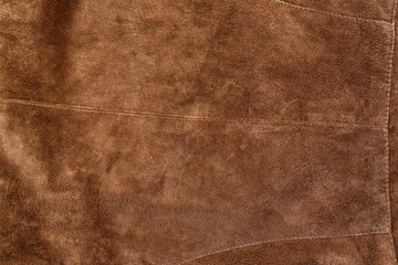 Part of brown textured suede clothing. Genuine leather