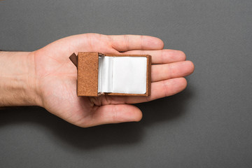 Fototapeta premium Male palm with an empty open brown jewelry box. Present. Black background