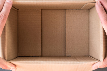 Man hands open empty cardboard box, inside view. Close up