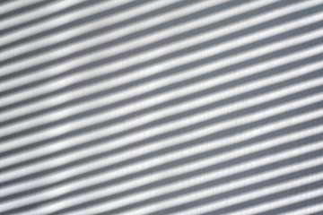White wooden background with shadow from the blinds. Sunny day, interior