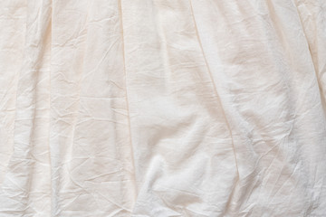 Crumpled cotton fabric with pleats. Ivory